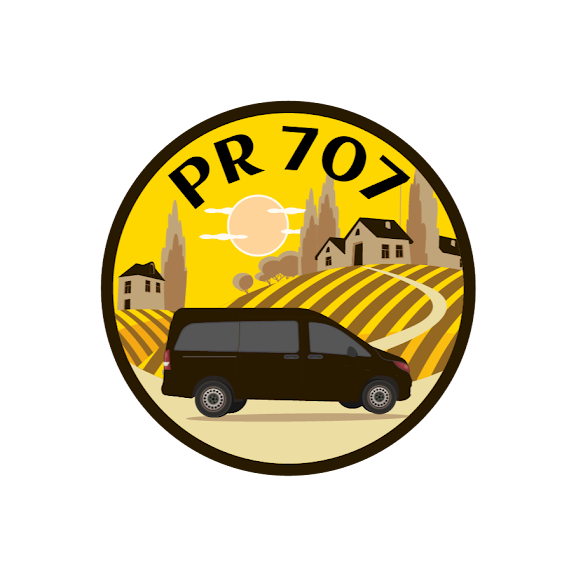 Circular logo: a black van on a yellow and brown landscape with buildings and 