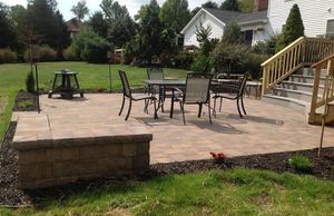 Two people discussing a garden landscape plan outdoors in a sunny yard.