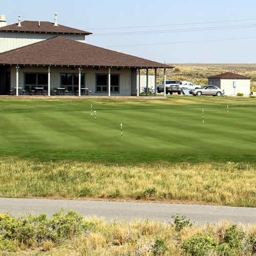 A golf course with a house in the background