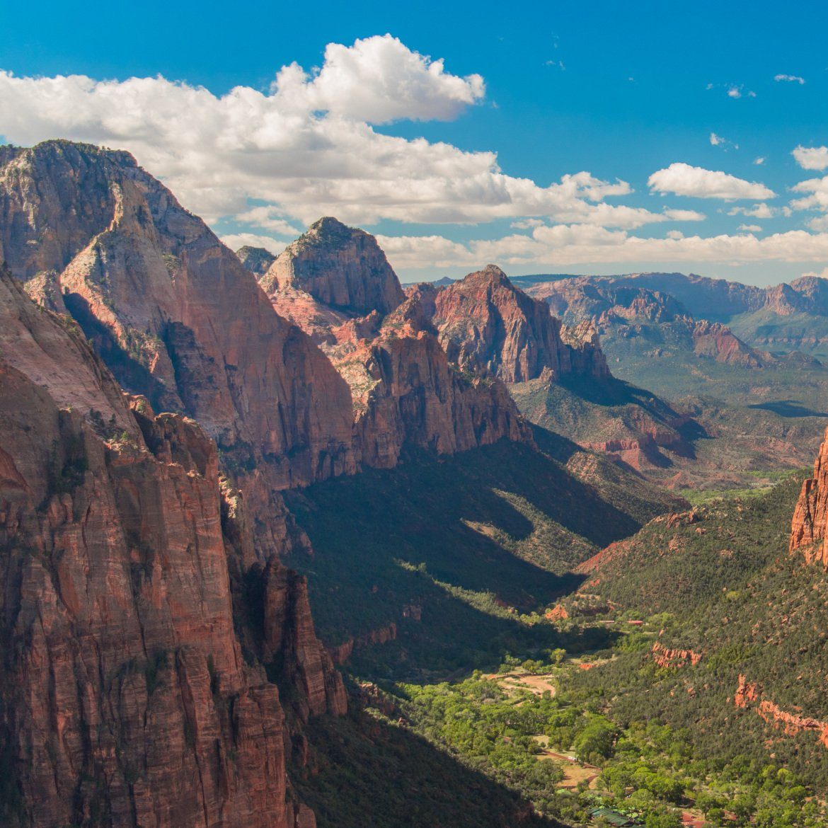 An aerial view of a valley surrounded by mountains on a sunny day. The Outlaw Trail.