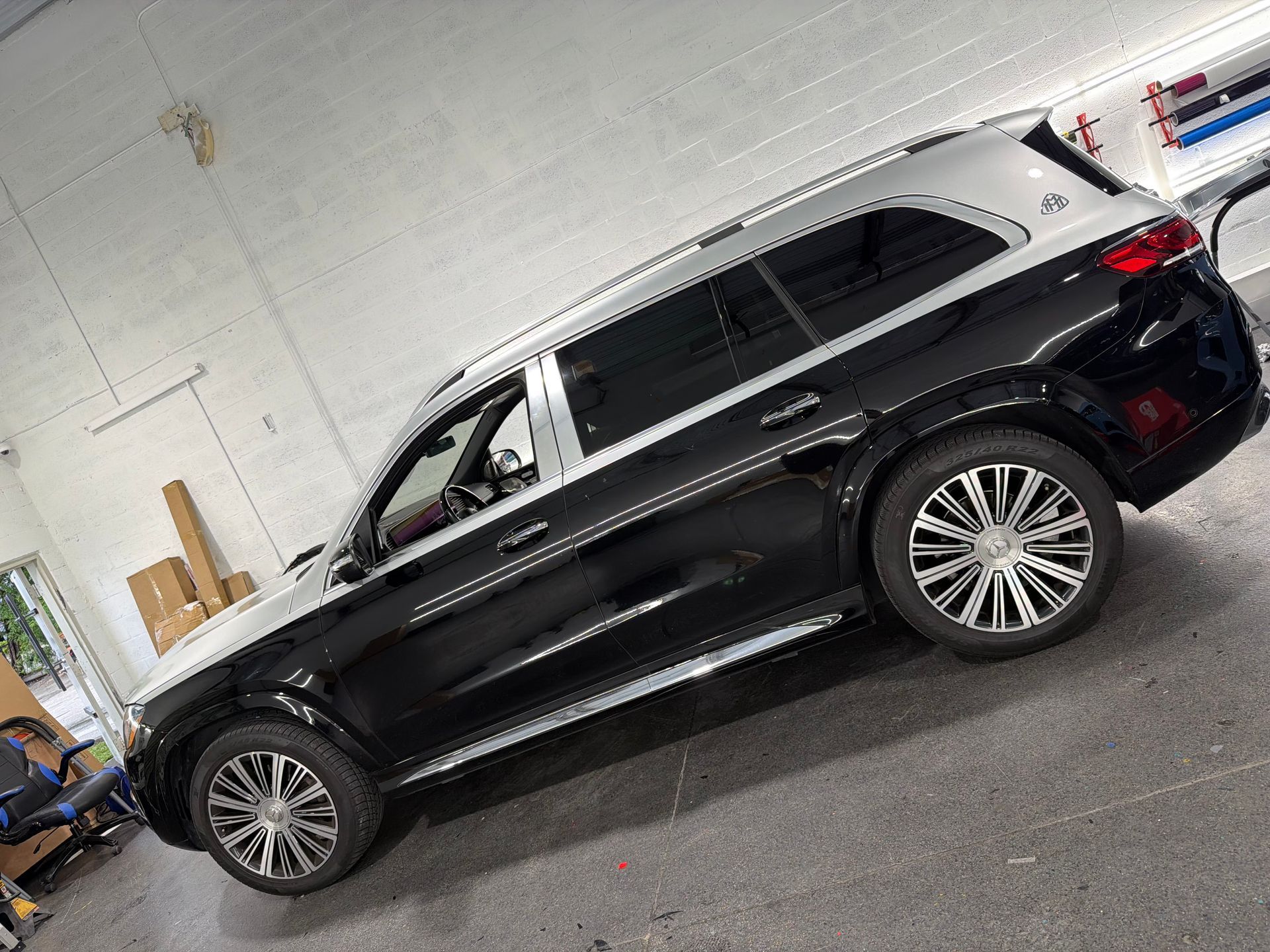 Black SUV parked indoors in a garage, side view with silver trim.