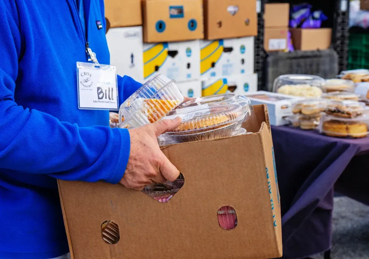 Volunteer handing out bags at a CROS food pantry.