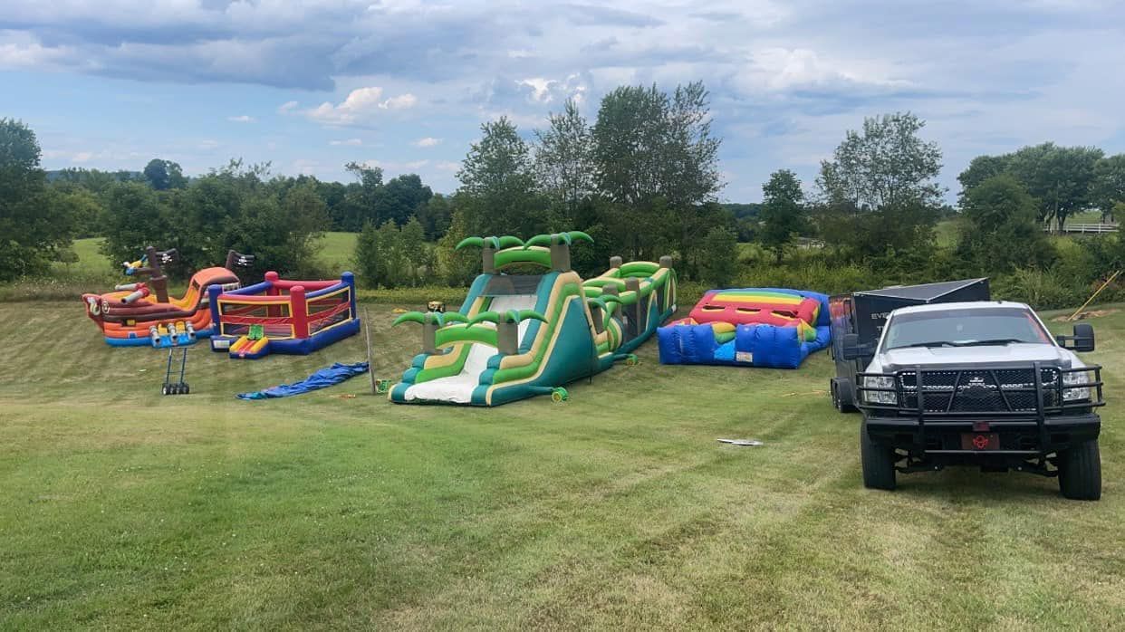 A bunch of bouncy houses are sitting on top of a lush green field.
