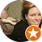 A woman is smiling in a circle with an orange star.