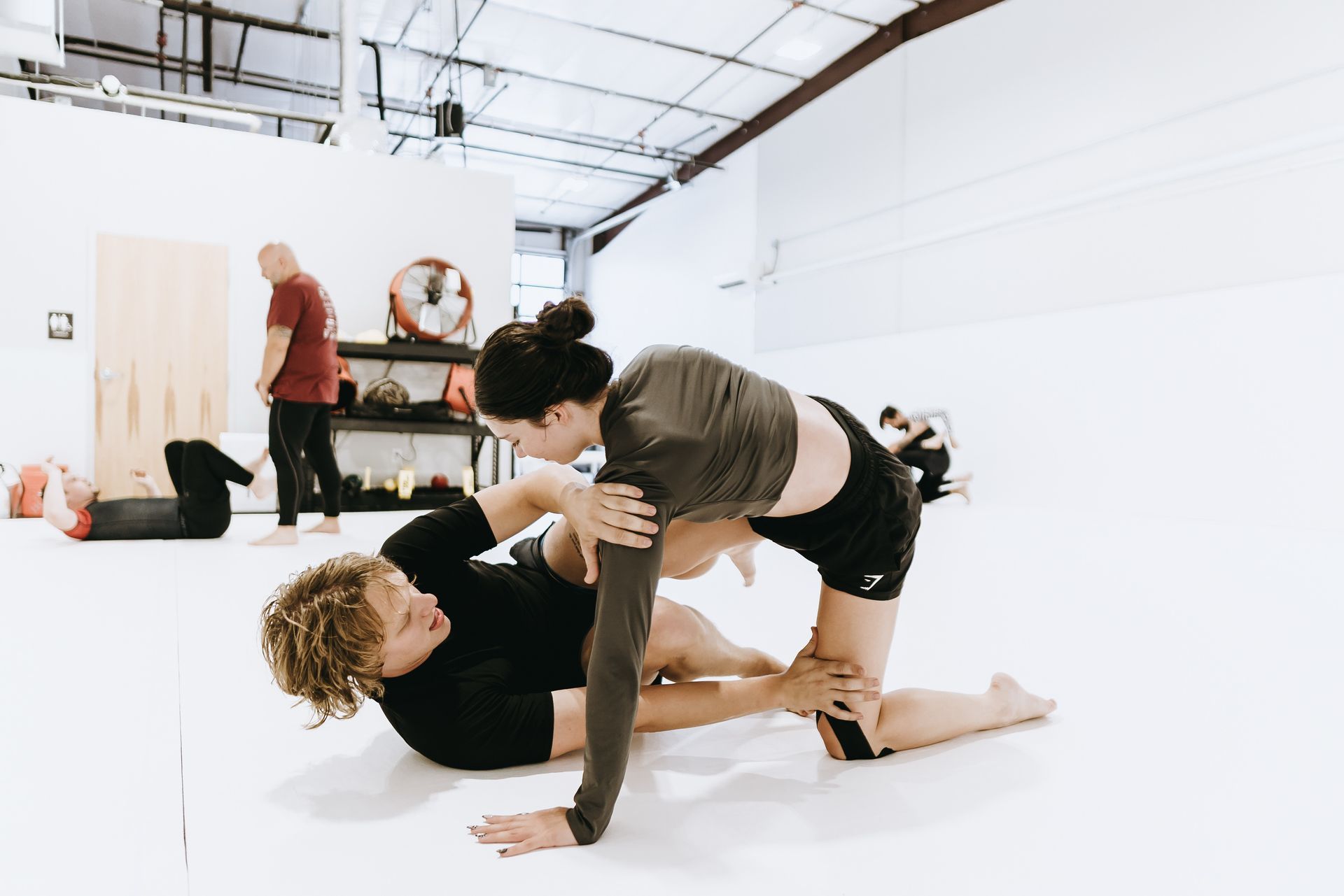 Adults practicing Brazilian Jiu-Jitsu drilling techniques at Jiu-Jitsu Hub in Georgetown, Texas.