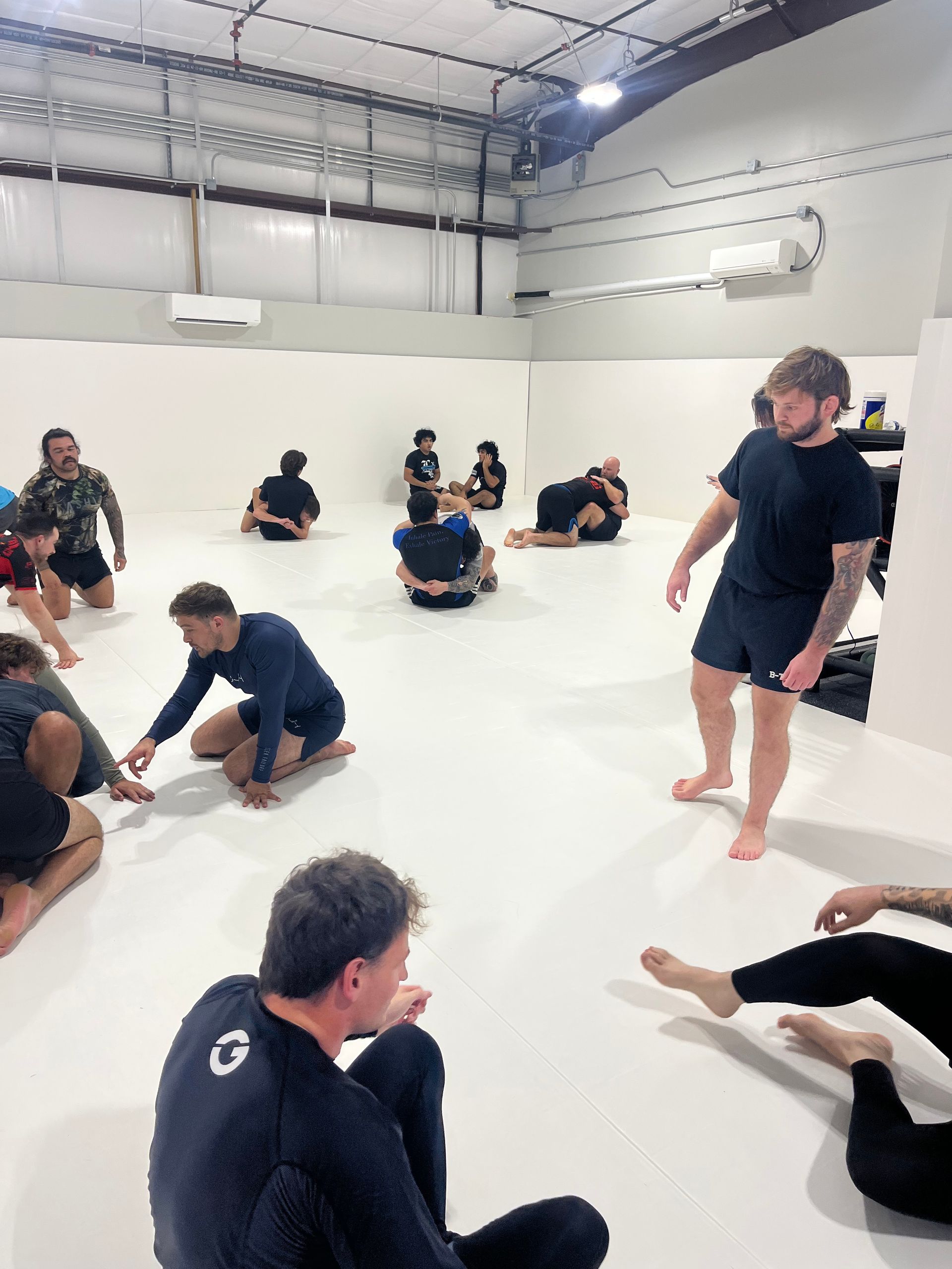 Adult students drilling Brazilian Jiu-Jitsu technique at Jiu-Jitsu Hub in Georgetown, Texas.