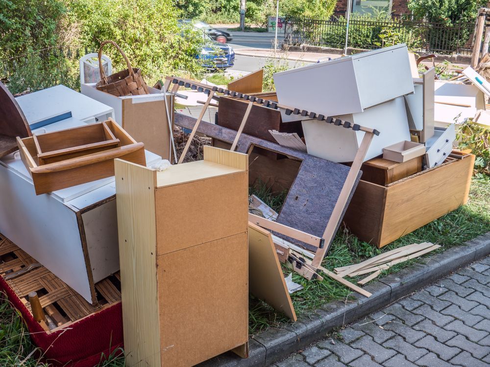 Pile of discarded furniture and cardboard boxes stacked at a curbside