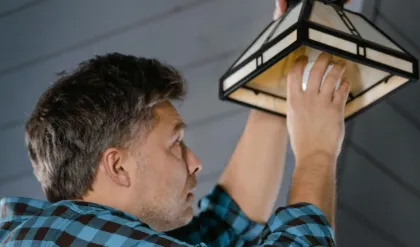 Hughes Handyman installing a ceiling light fixture during an electrical job in Gurnee, IL.