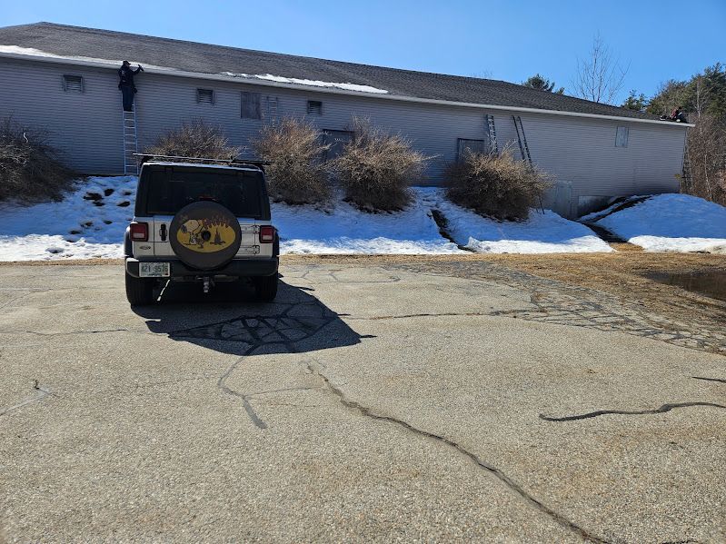 New England Gutter Systems technician installing seamless six inch gutters at Monadnock Tennis Club commercial gutter installation project in New Hampshire