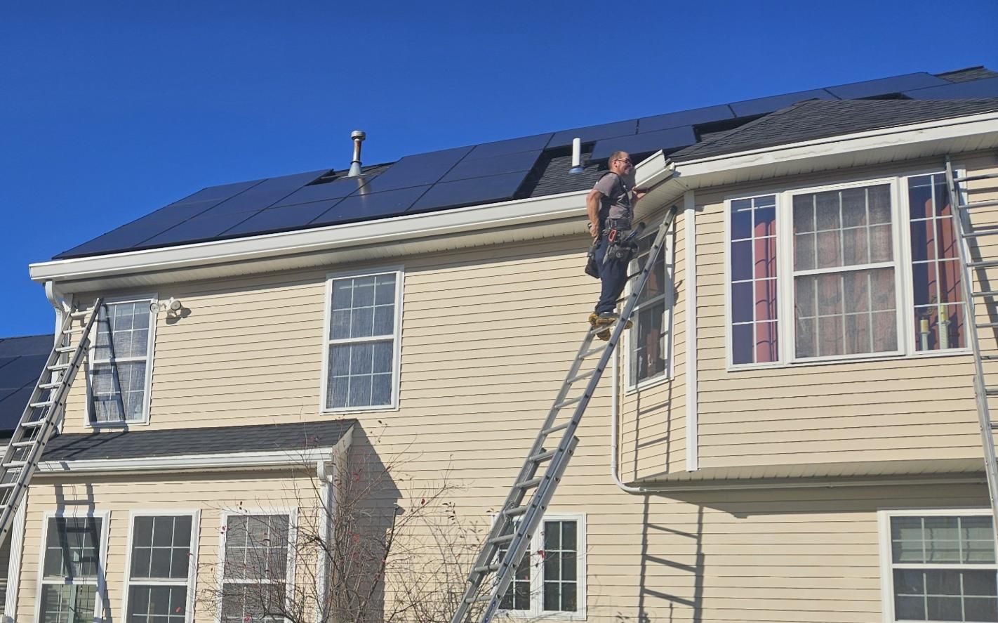 Installing 8-inch K-style seamless gutters on a New Hampshire home with solar panels