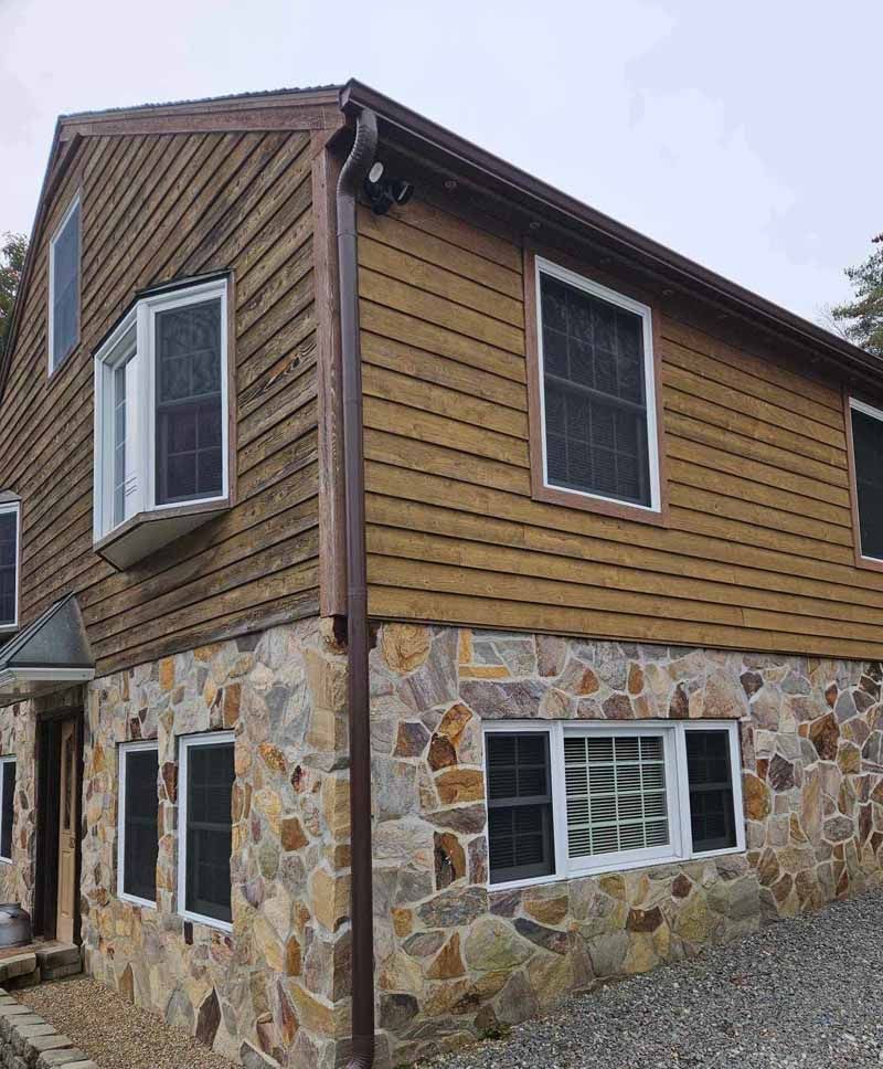 A large house with a wooden siding and a stone foundation.