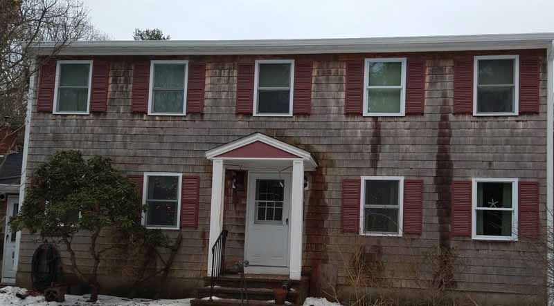 A large house with red shutters and a white door