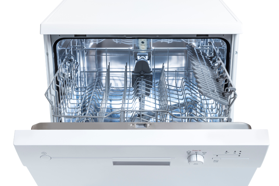 Dishwasher interior with clean white plates, utensils, and whisk in the rack.