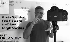 Man filming with a Nikon camera, discussing video optimization for YouTube and Google searches. Whiteboard in background.