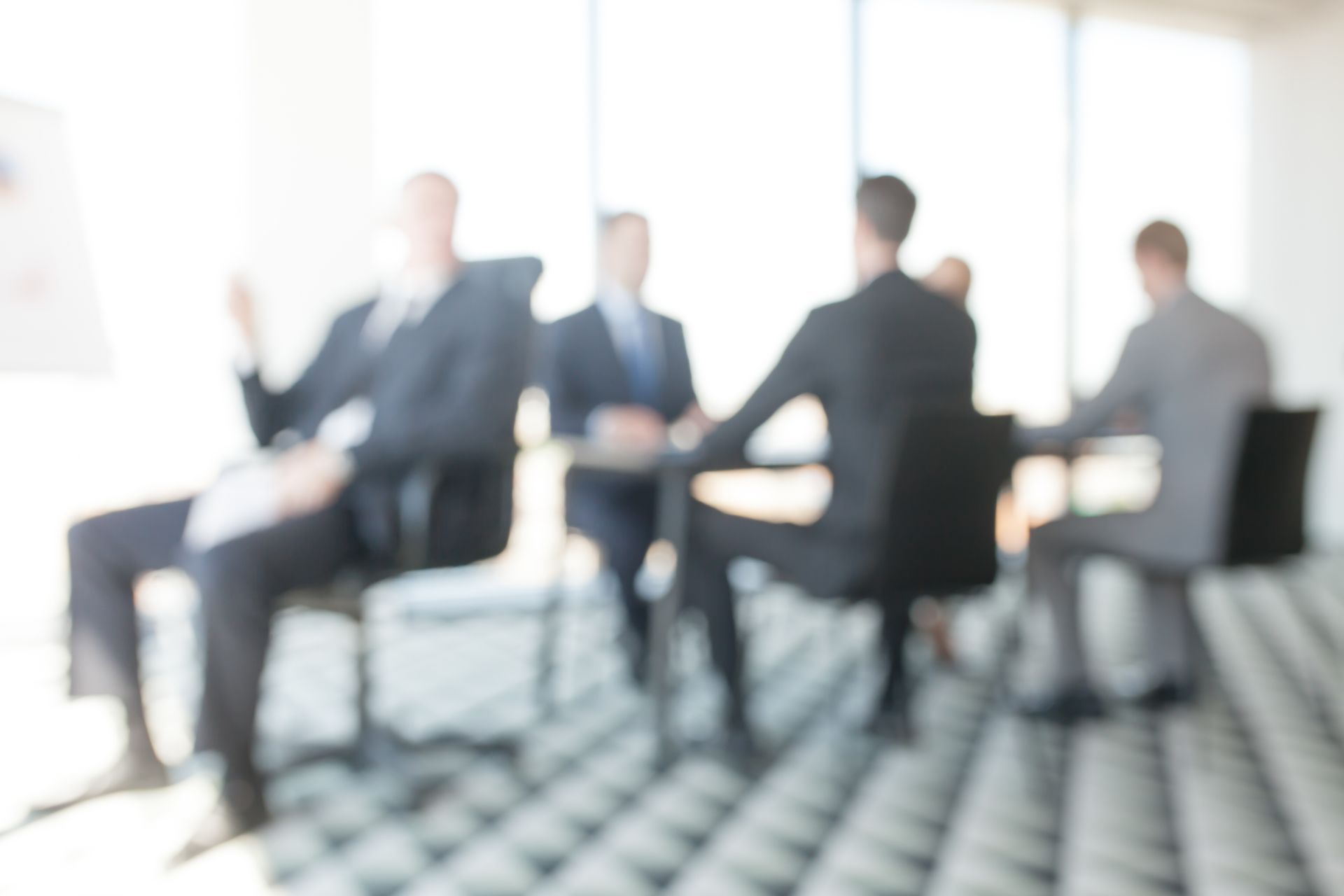 Un gruppo di uomini d'affari è seduto attorno a un tavolo in una sala conferenze.