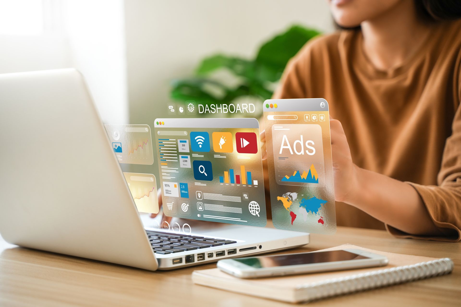 Une personne travaillant sur un ordinateur portable avec des publicités numériques flottantes et des icônes d'applications affichées à l'écran, dans un environnement de bureau lumineux.