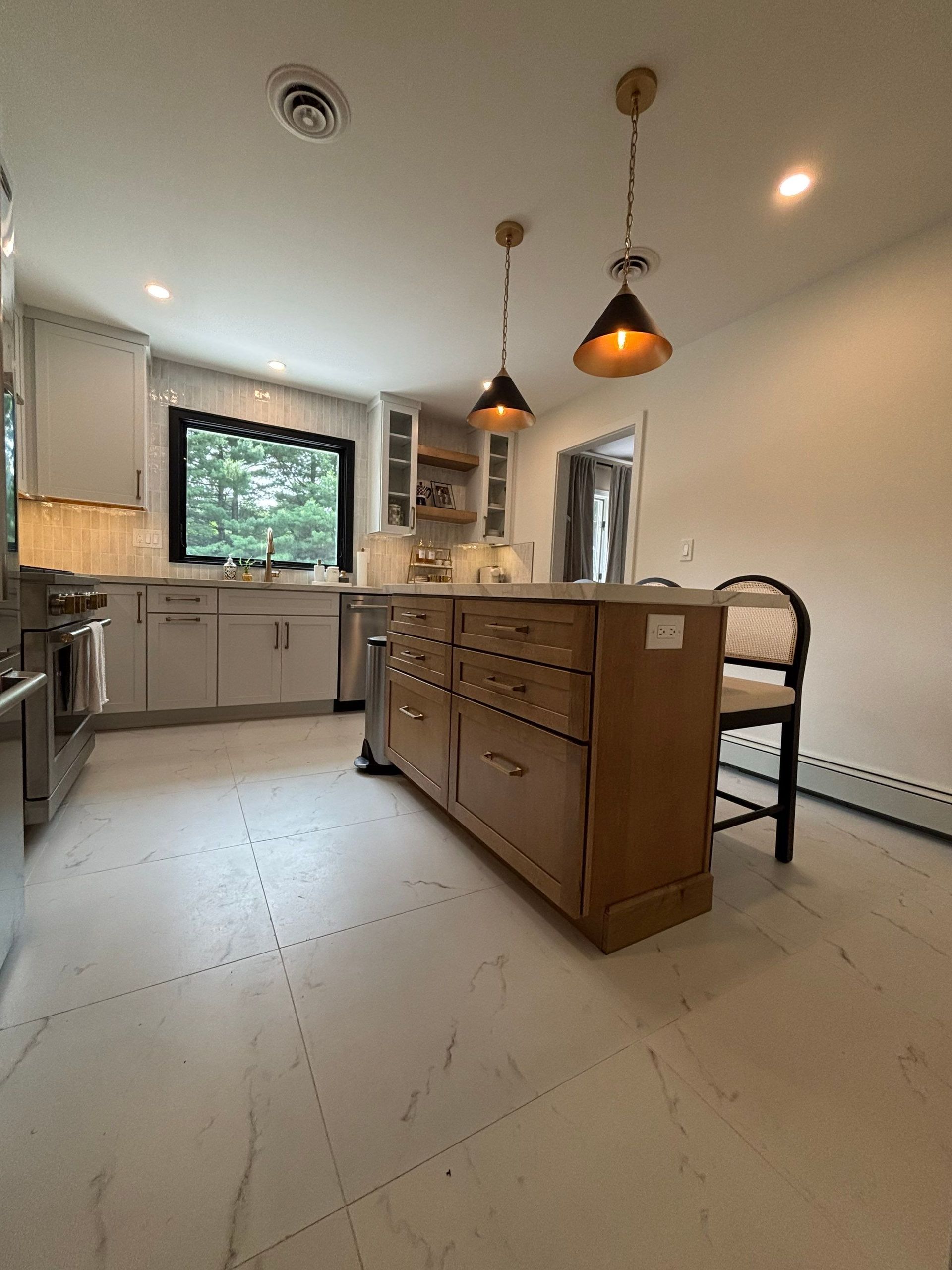 Kitchen with a wooden island, pendant lights, and stainless steel appliances.