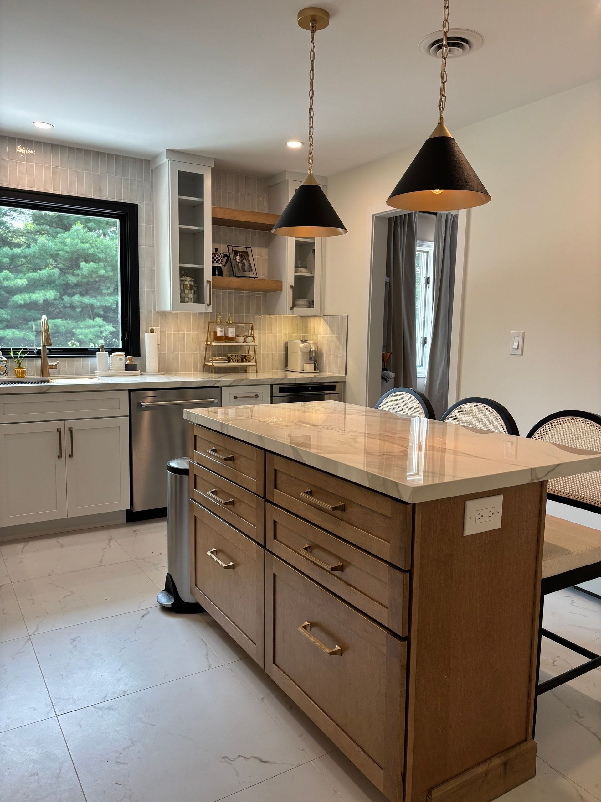 Kitchen with an island, cabinets, and two pendant lights.