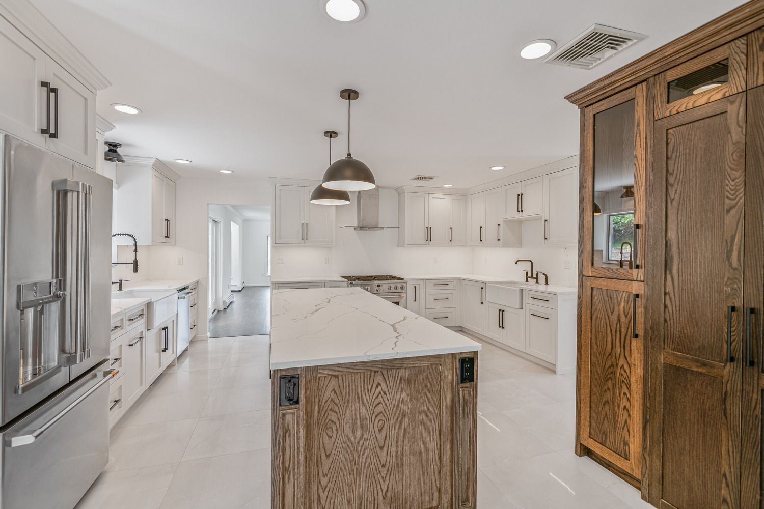 Modern kitchen with white cabinets, stainless steel appliances, and a wooden island.
