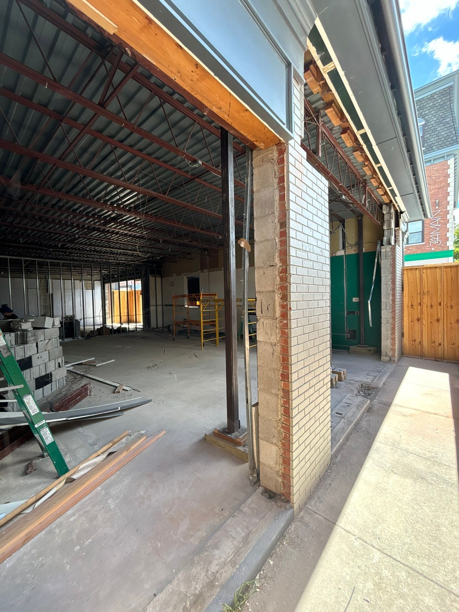Building exterior under construction with exposed interior. Brick and metal structure.