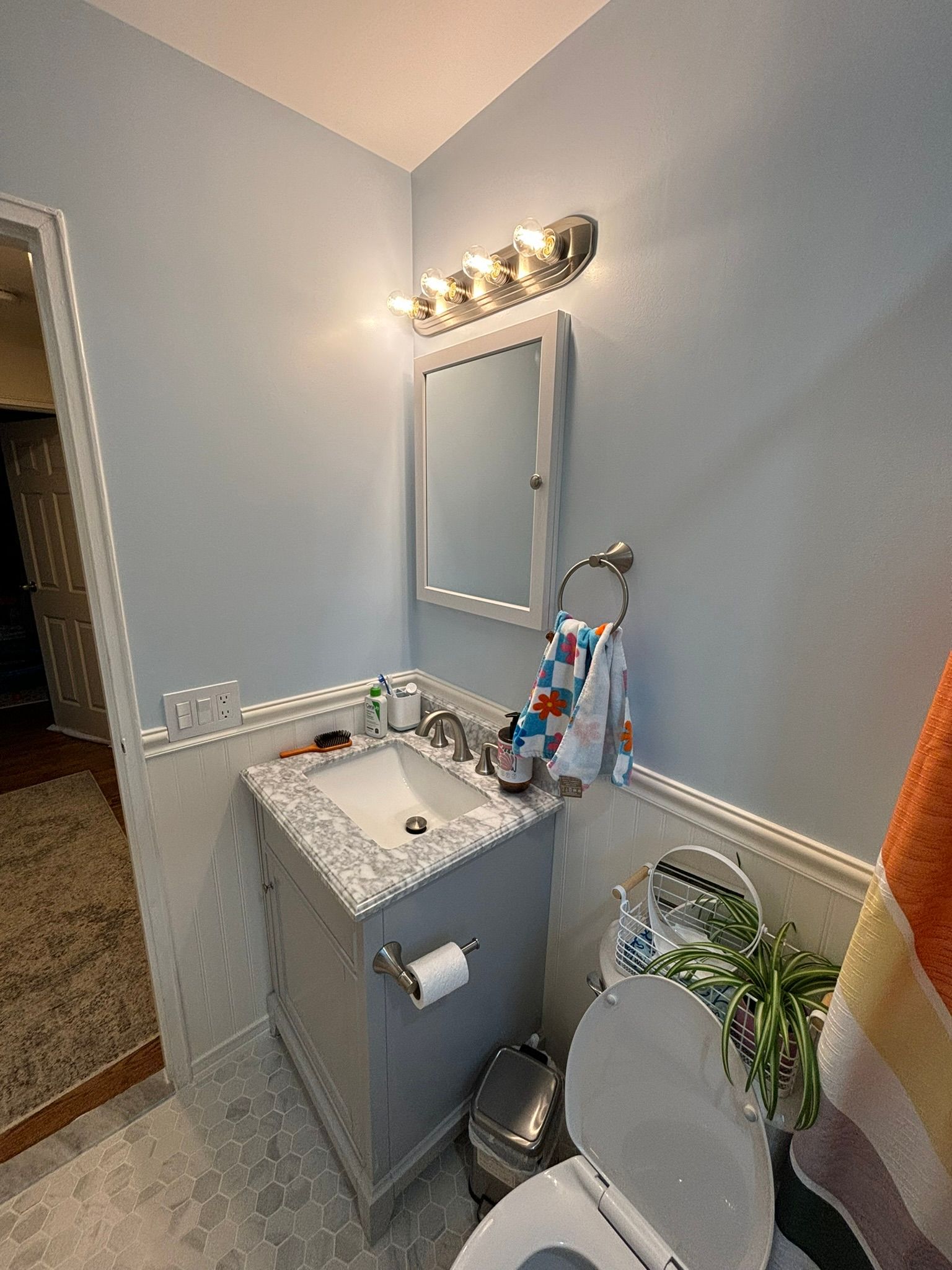 Bathroom with gray vanity, blue walls, a mirror, and a toilet.