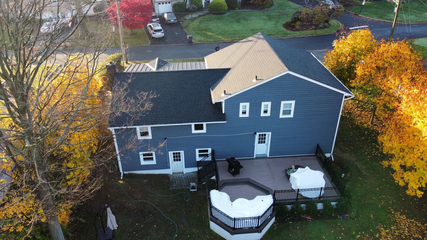 Blue house with deck and fall foliage.