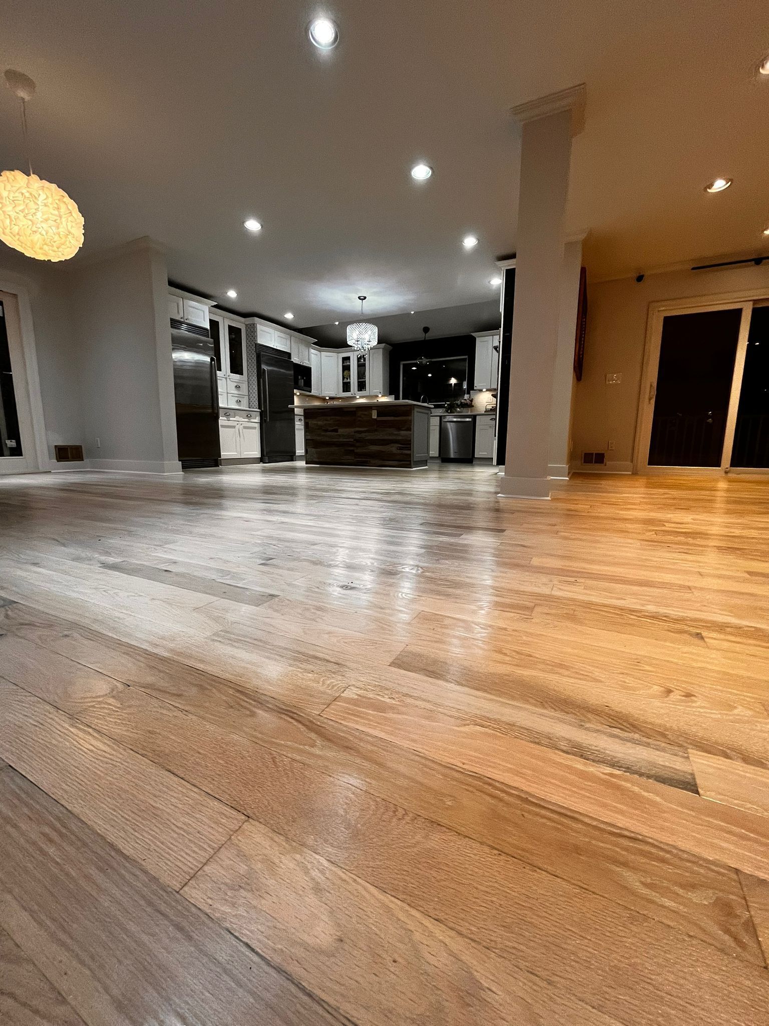 Hardwood floor in a modern kitchen with island and recessed lighting.