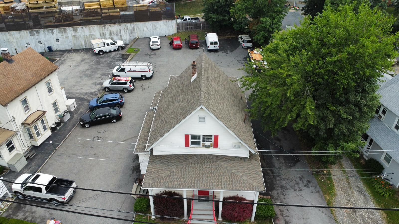 An aerial view of a building with a parking lot and several vehicles.