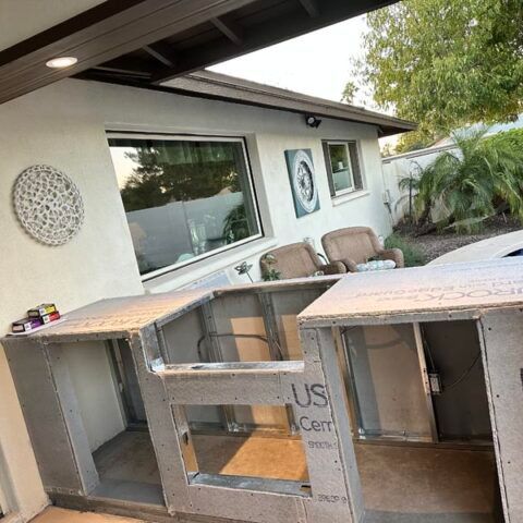 Patio with stacked cardboard crates and a house exterior in the background