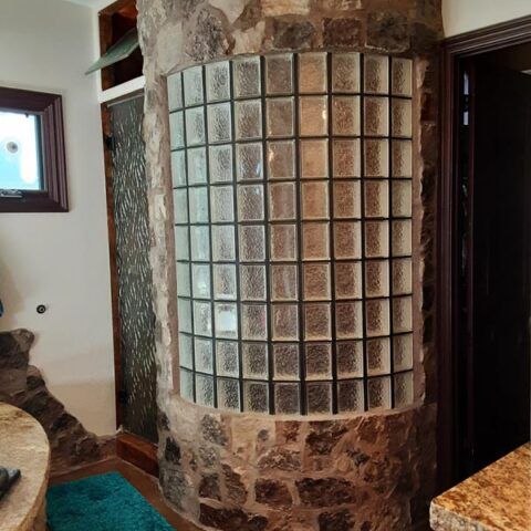 Curved glass block wall with stone accents in a room interior