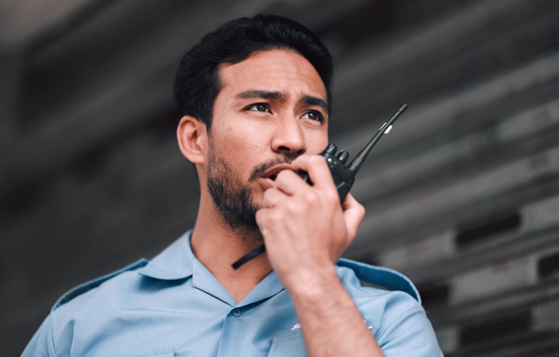 A man with a beard is talking on a walkie talkie.