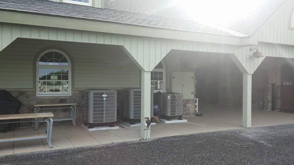 Covered outdoor seating area with benches, air conditioners, and a parked scooter beside a building Covered outdoor seating area with benches, air conditioners, and a parked scooter beside a building