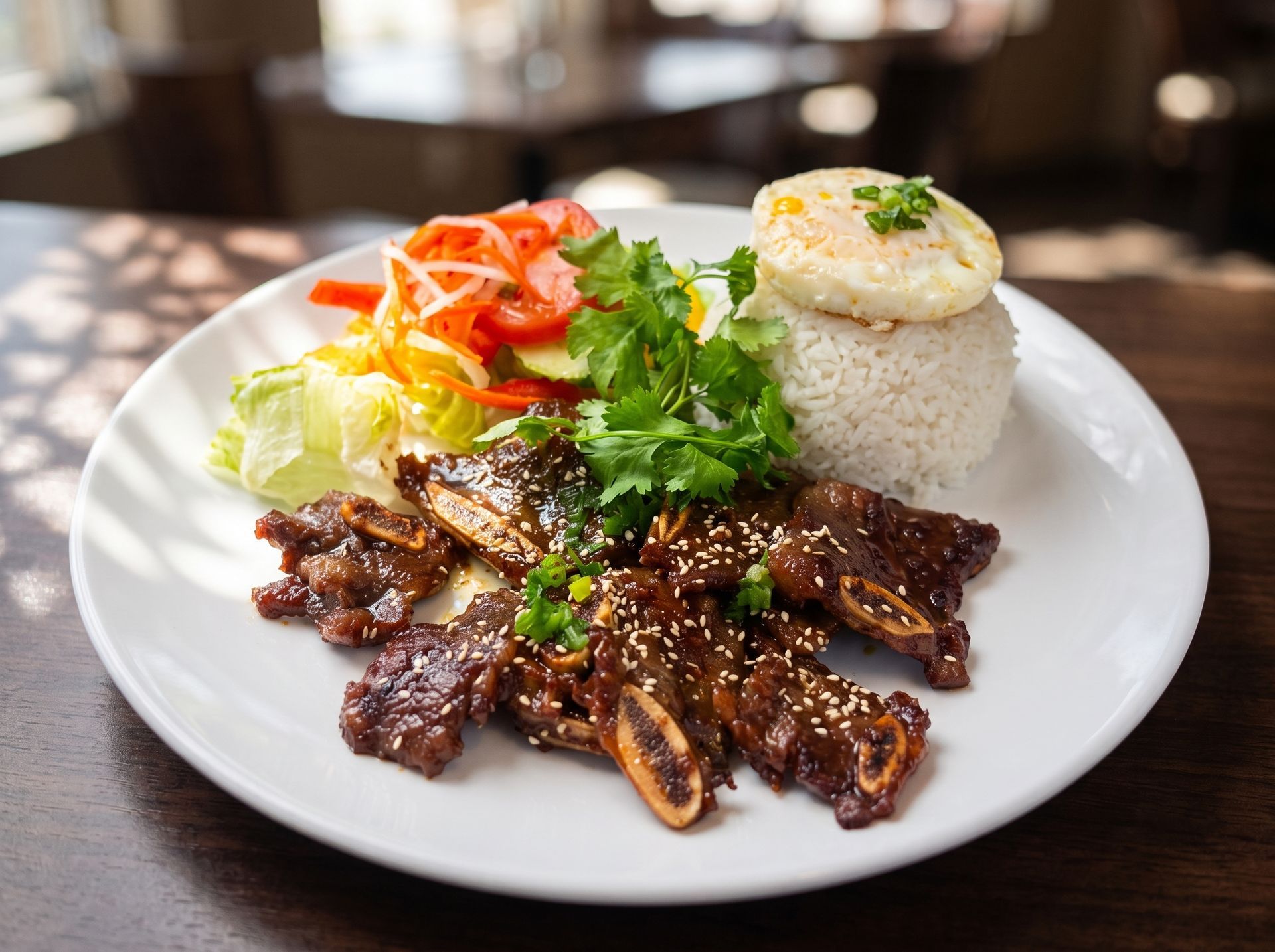 Plated grilled beef with rice, salad, and garnish on a white dish at a restaurant table