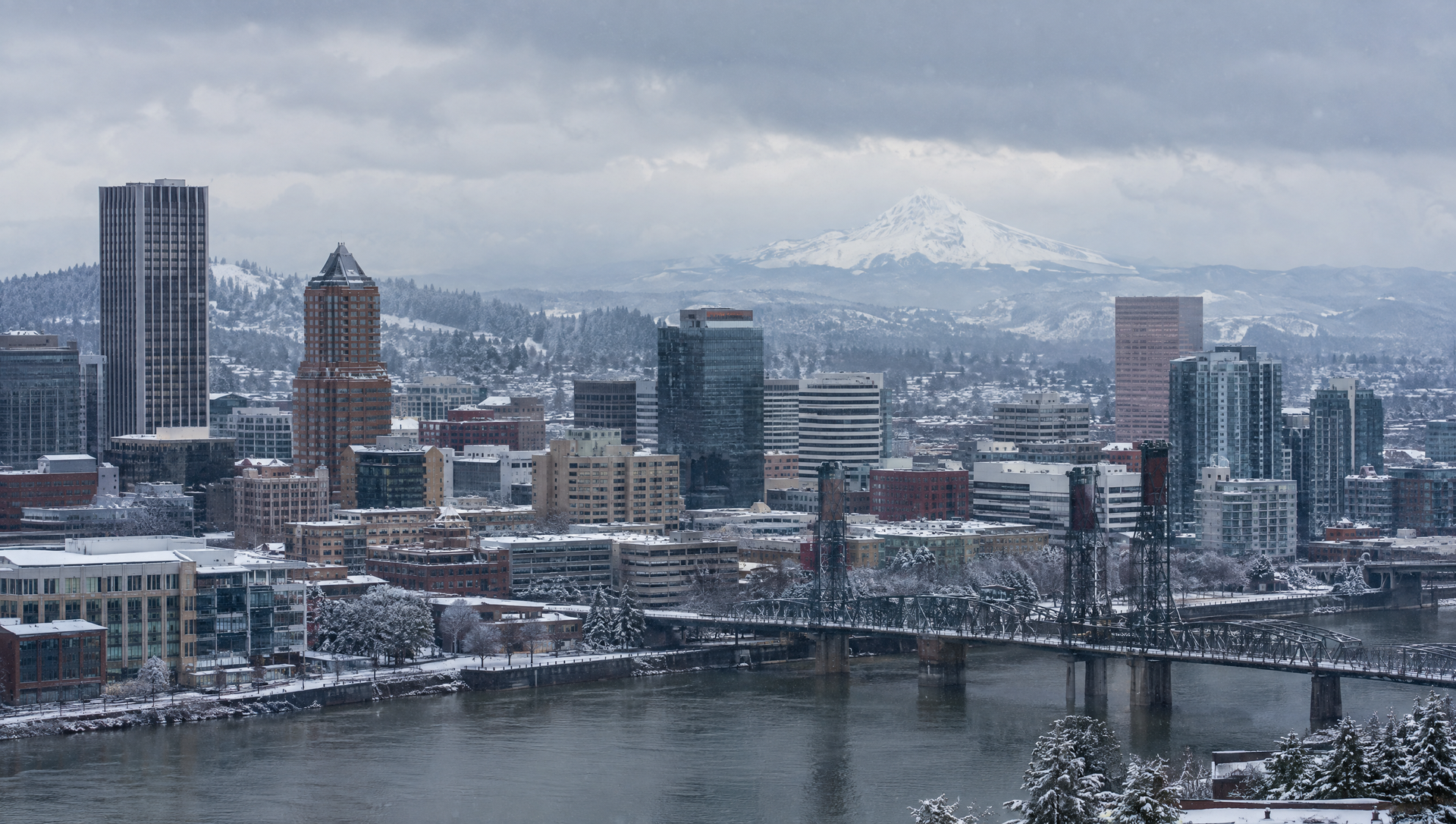 Downtown Portland skyline in winter snow with Mount Hood in the background