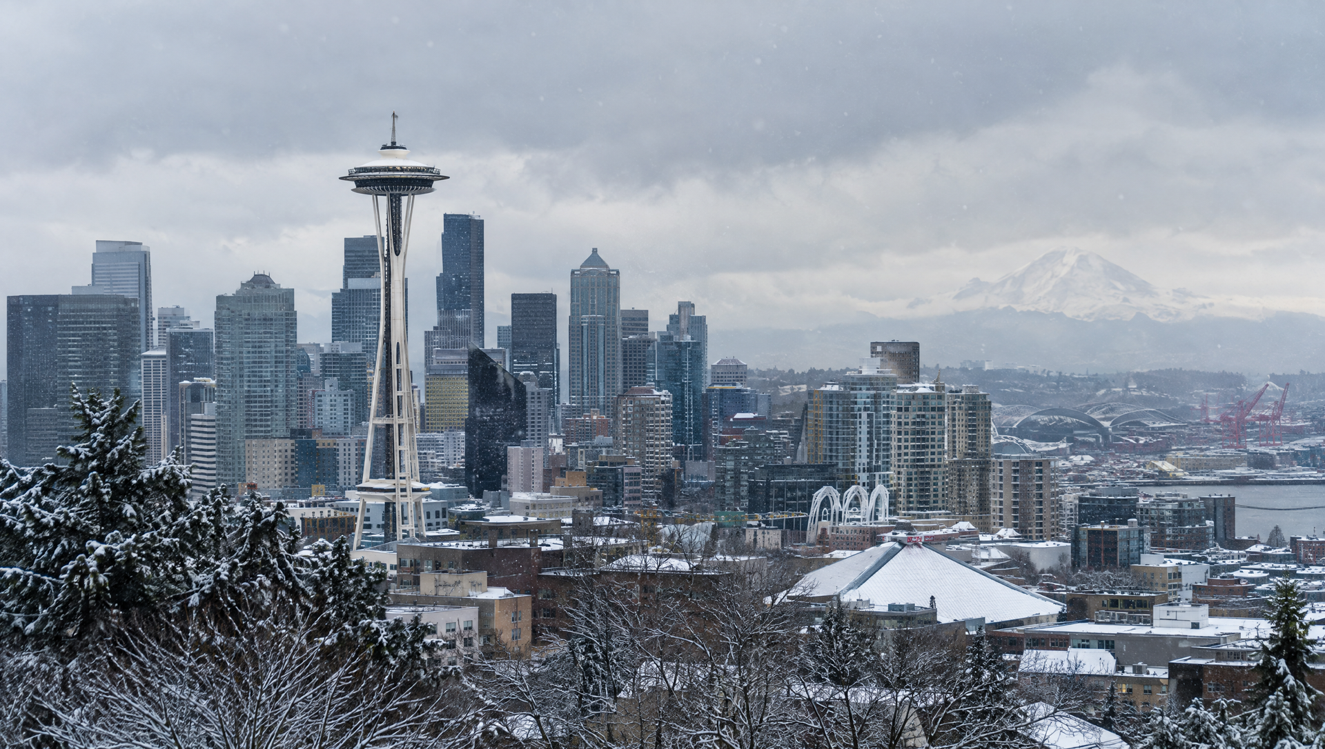 Downtown Seattle skyline in winter snow with the Space Needle and Mount Rainier