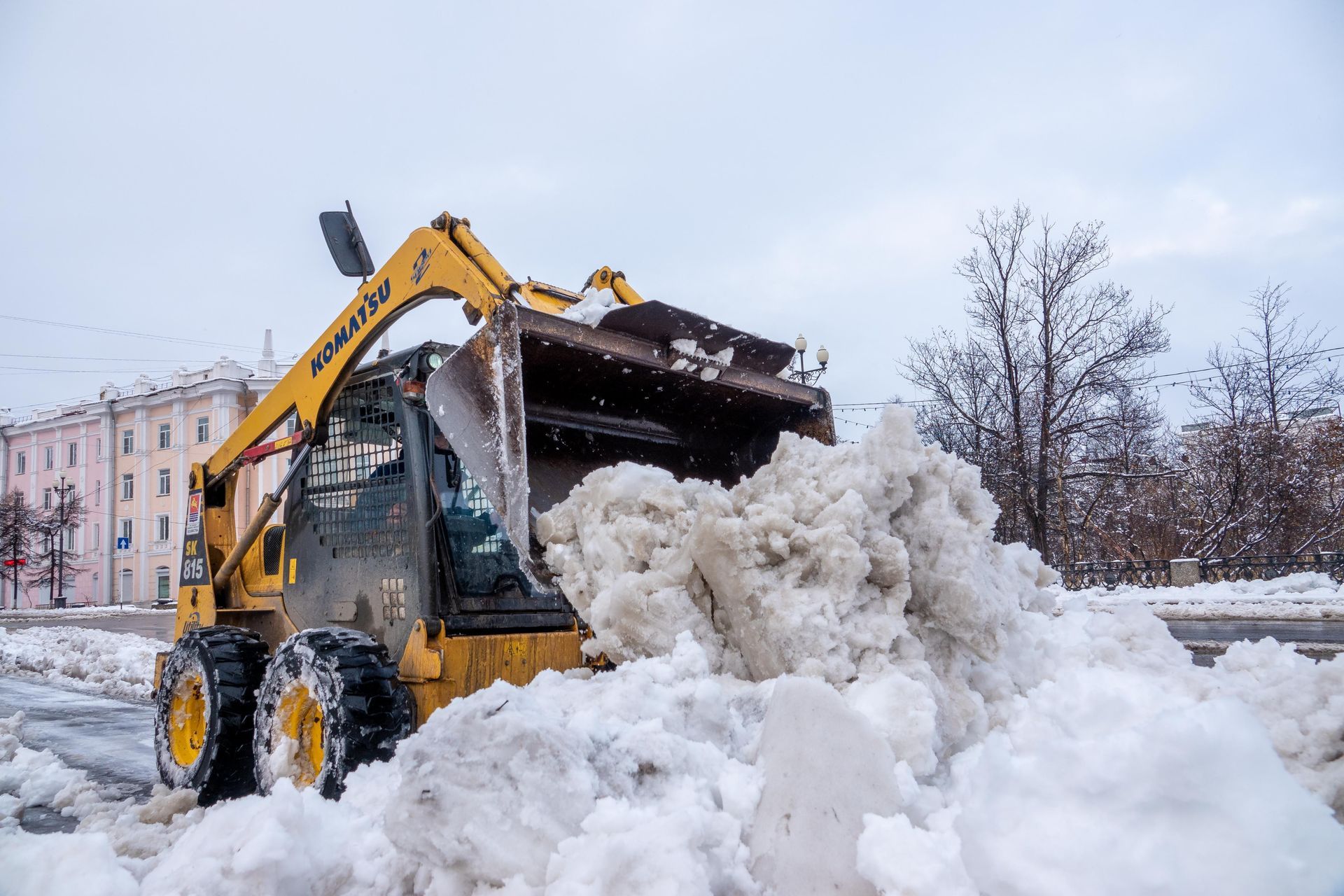 Snowplow clearing snow from a road with an orange blade