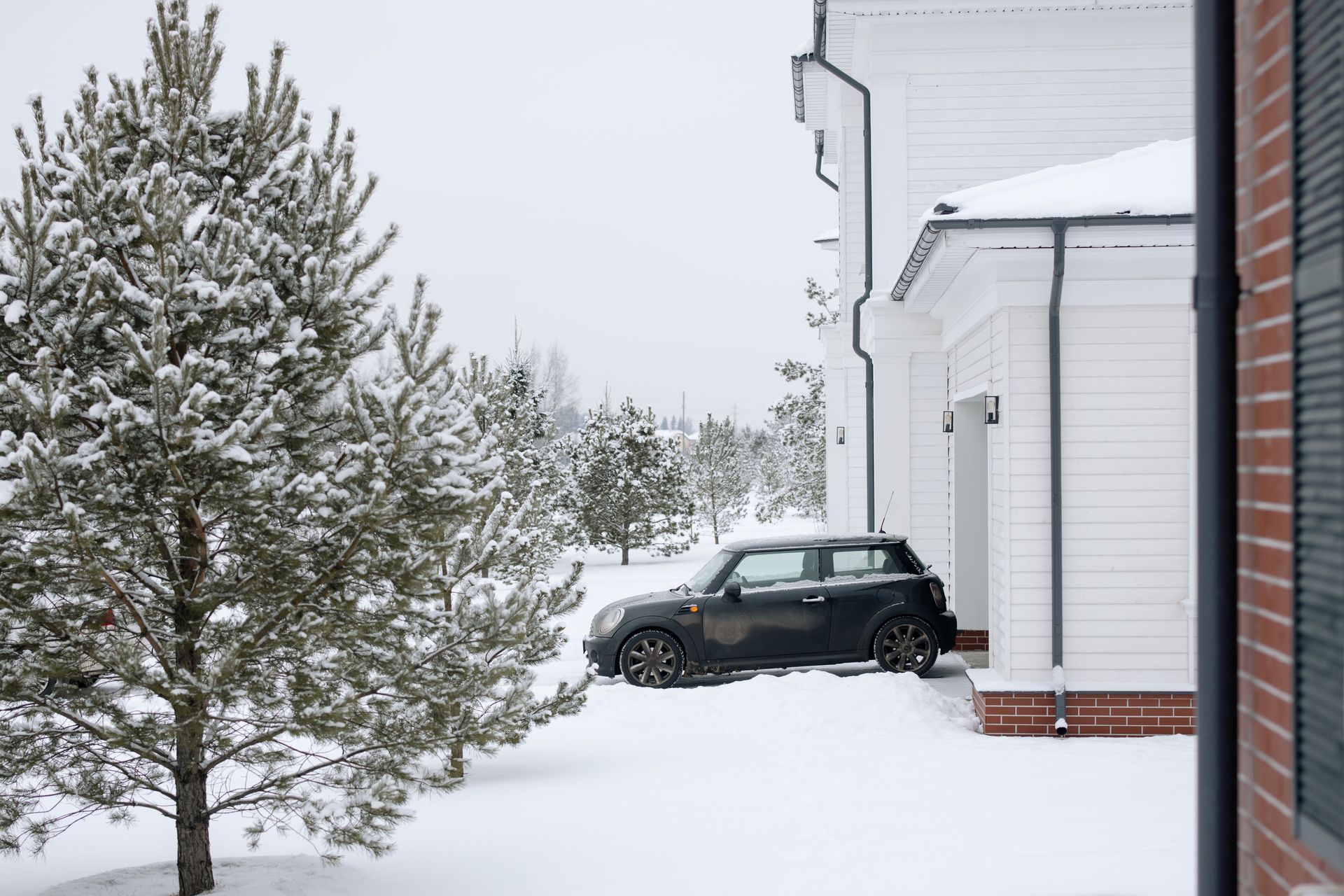 Snow-covered residential driveway and walkway in a Pacific Northwest neighborhood cleared by professional snow removal