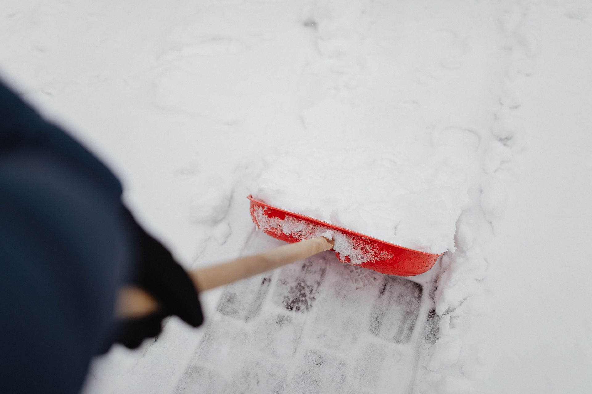 Snow shovel clearing a path through deep snow outdoors
