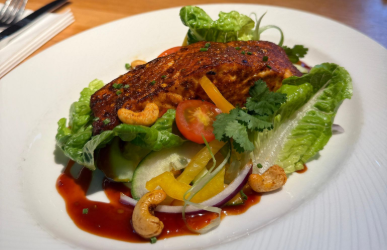 a close up of a plate of food with a salmon salad on the table.