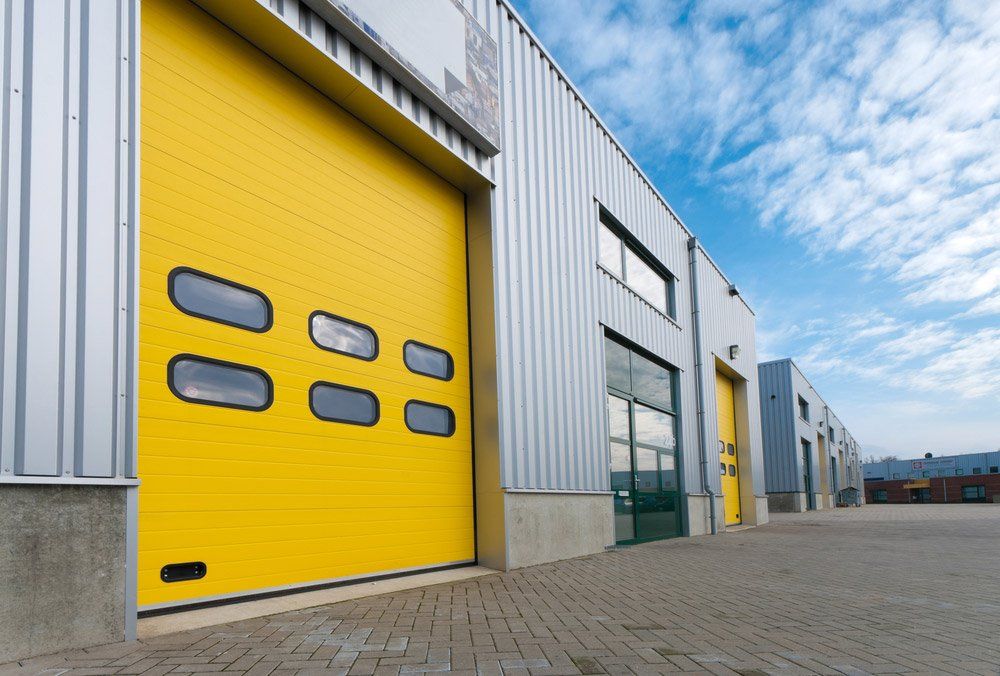 Industrial Warehouse With Yellow Roller Doors — Darwin Roller Door Services In Tivendale NT