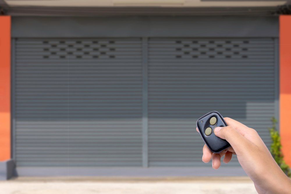 Woman Hand Using Garage Remote Control — Darwin Roller Door Services In Tivendale NT
