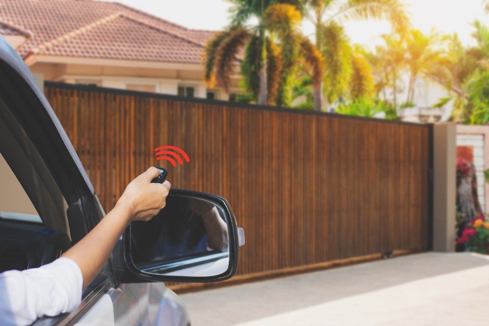 Woman In Car Using A Garage Remote Control — Darwin Roller Door Services In Tivendale NT