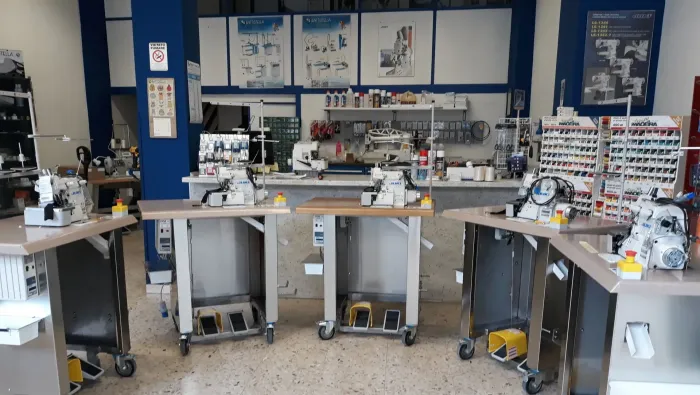 Aula di scienze con banchi da laboratorio, microscopi e materiali disposti ordinatamente in tutta la stanza.