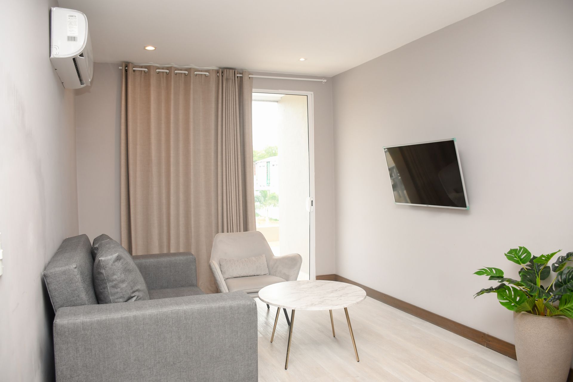 Una sala de estar con sofá, silla, mesa y televisión  ciela hotel