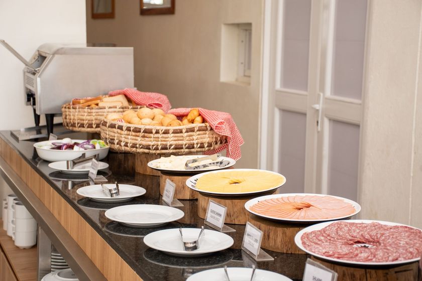 Desayuno buffet con platos y cestas de comida sobre ella en Ciela Hotel