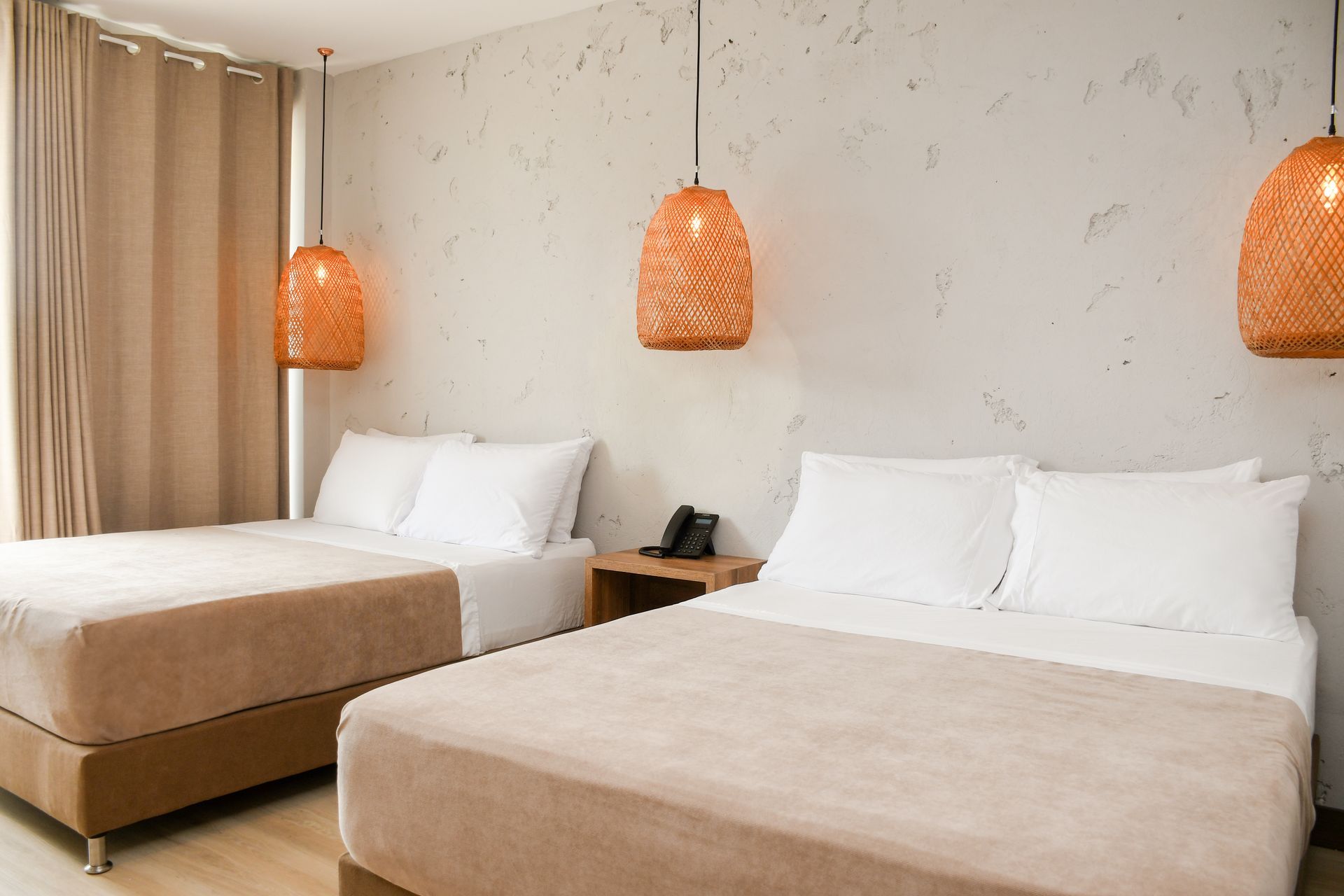 Una habitación de hotel con dos camas y dos lámparas colgando del techo  ciela hotel