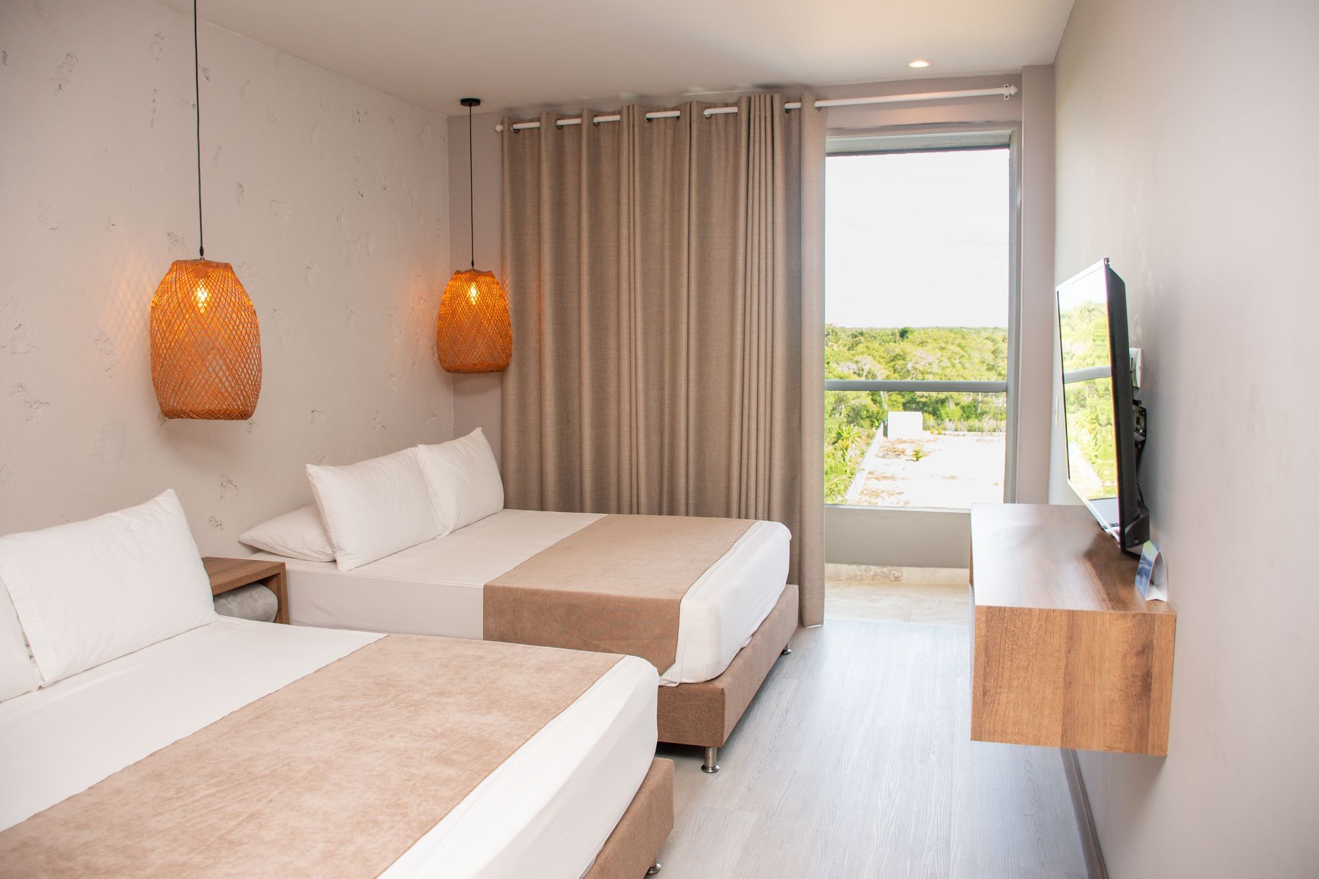 Una habitación de hotel con dos camas y un televisor de pantalla plana.