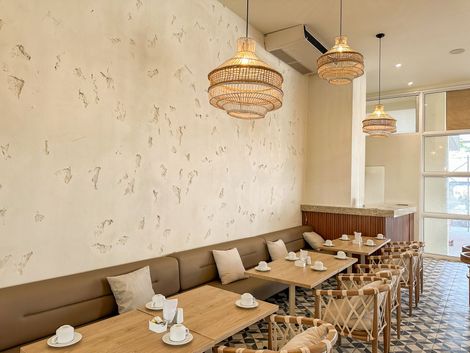 Restaurante con mesas y sillas y un sofá largo en Ciela Hotel