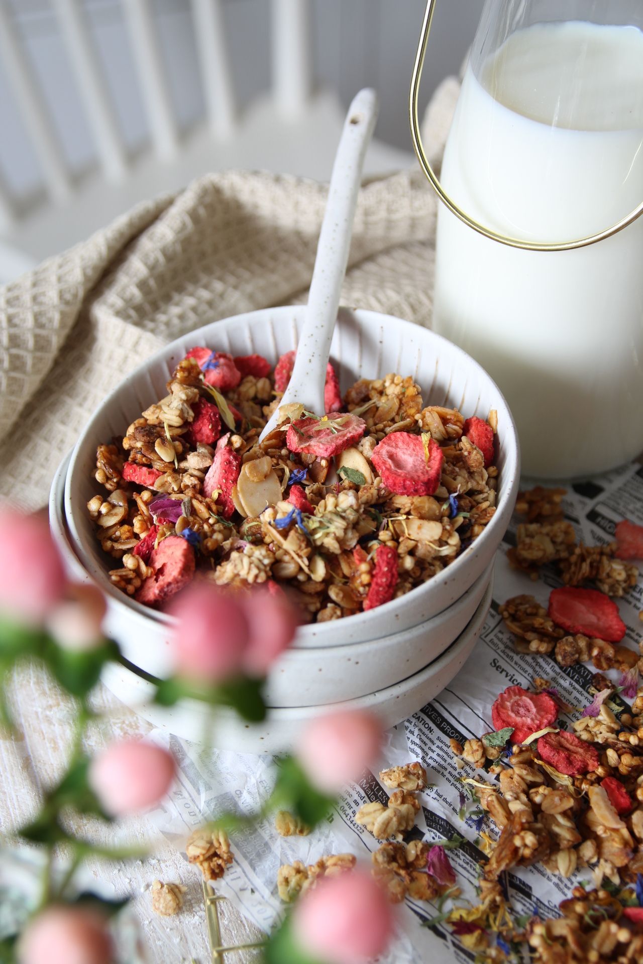 knuspriges Granola mit Honig, Erdbeeren und essbaren Blüten