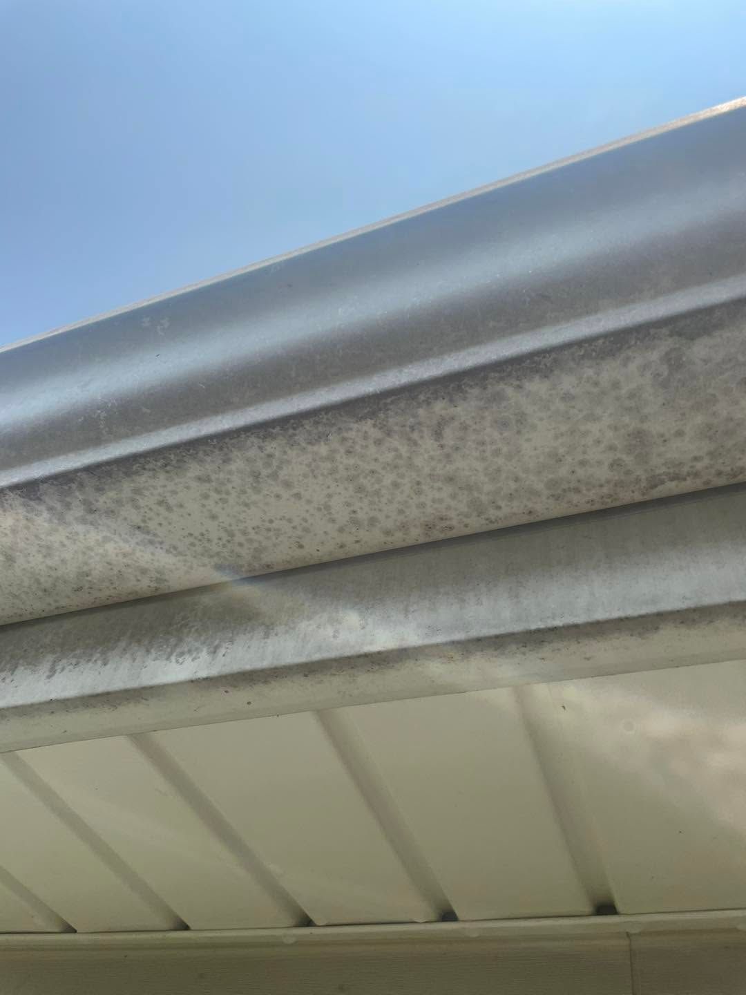 Close-up of a weathered metal roof edge against a blue sky